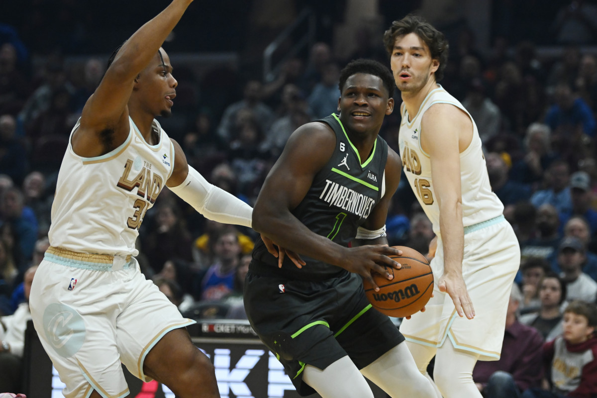 Nov 13, 2022; Cleveland, Ohio, USA; Minnesota Timberwolves guard Anthony Edwards (1) drives to the basket against Cleveland Cavaliers forward Isaac Okoro (35) and forward Cedi Osman (16) during the first half at Rocket Mortgage FieldHouse.